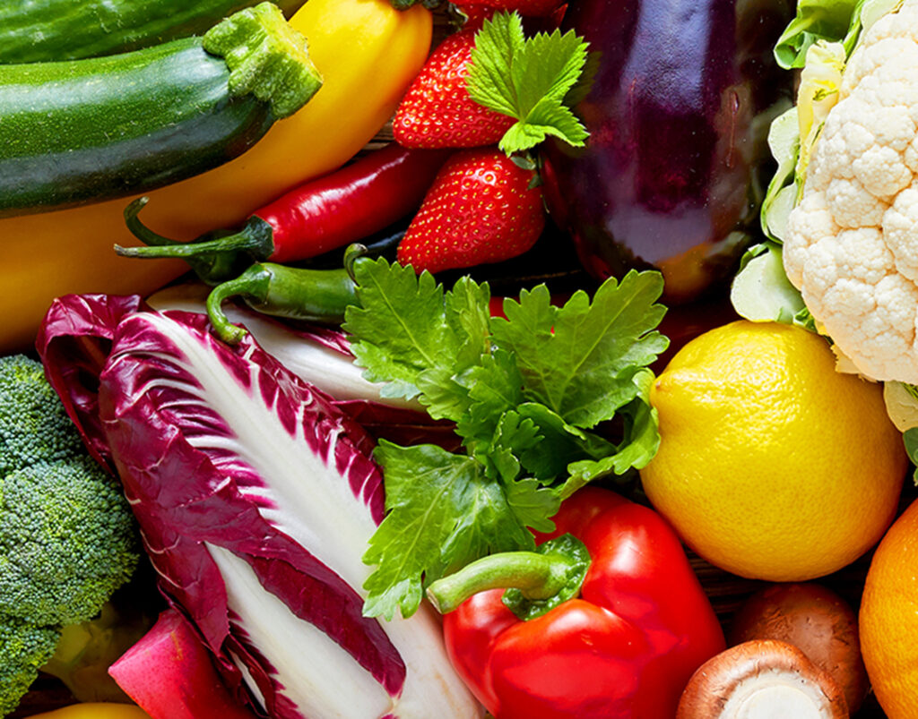 Panoramic wide organic food background concept with full frame pile of fresh vegetables and fruits mix forming bright colorful image